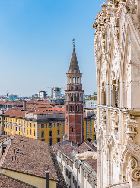Milan Cathedral rooftop view with cityscape and historic tower.