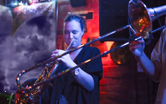 Musician playing trombone at Reduta Jazz Club concert.