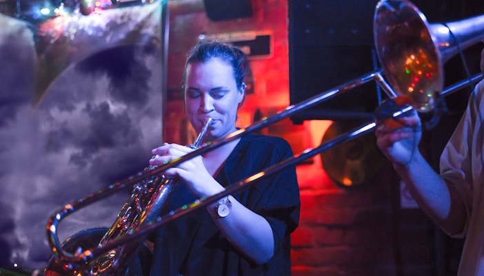 Musician playing trombone at Reduta Jazz Club concert.
