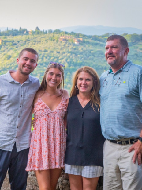 Tourists posing for a photo with Tuscan hills in the background during a semi-private Tuscany tour.