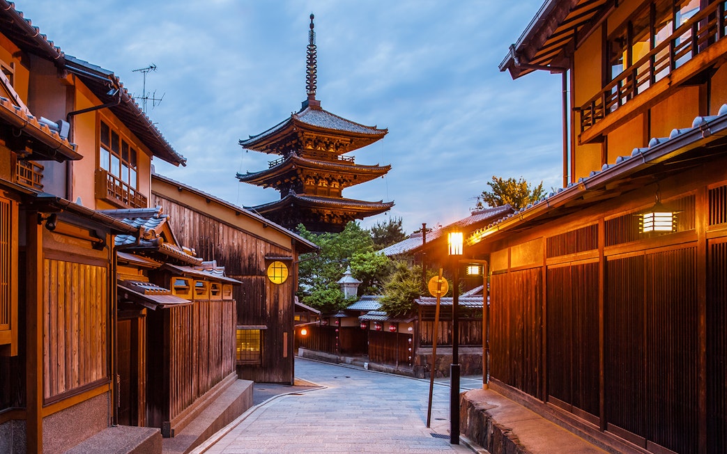 Japanese pagoda in Kyoto at twilight with traditional wooden buildings.