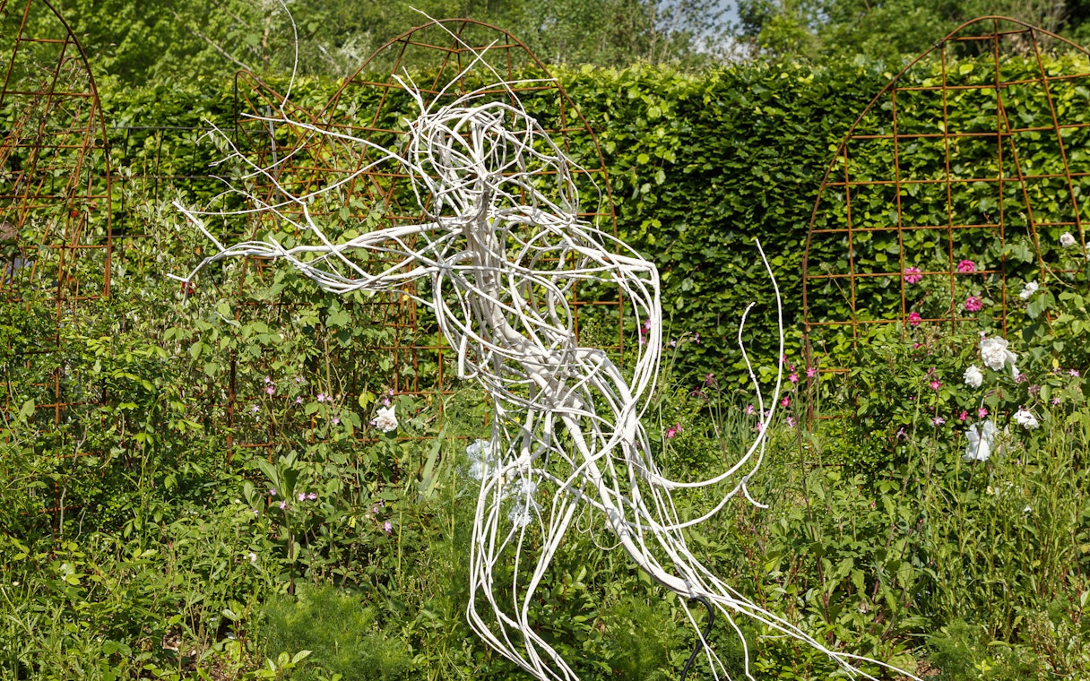 Sculpture in the gardens of Chaumont-sur-Loire Castle, surrounded by lush greenery.