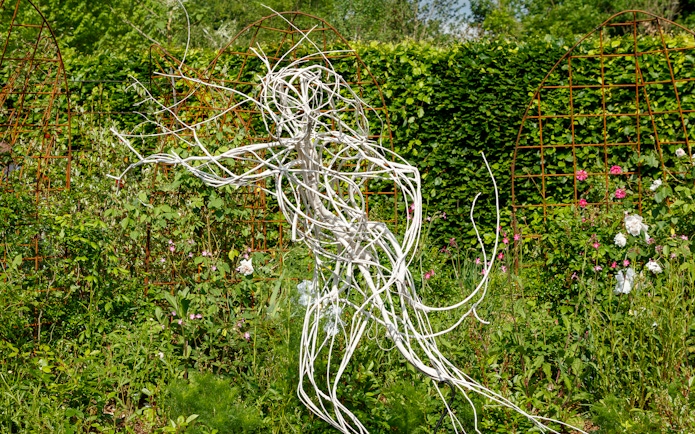 Sculpture in the gardens of Chaumont-sur-Loire Castle, surrounded by lush greenery.