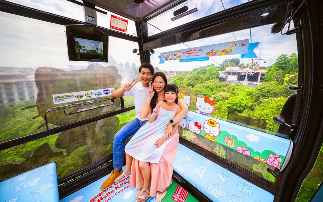 Tourists in Singapore Cable Car with city view, Hello Kitty theme, heading to S.E.A Aquarium.