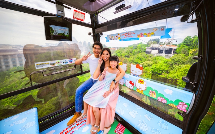 Tourists in Singapore Cable Car with city view, Hello Kitty theme, heading to S.E.A Aquarium.