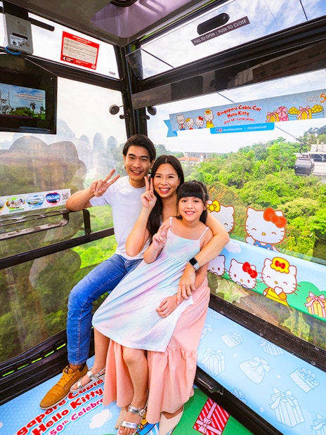 Tourists in Singapore Cable Car with city view, Hello Kitty theme, heading to S.E.A Aquarium.