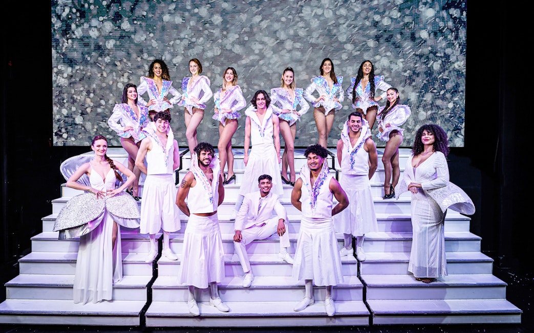 Cabaret performers in white costumes on stage in Paris for "My First Cabaret" show.