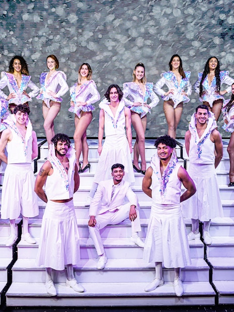 Cabaret performers in white costumes on stage in Paris for "My First Cabaret" show.