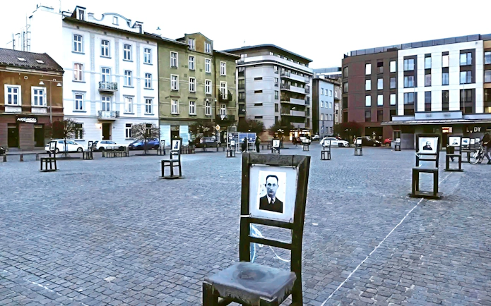 Empty chairs memorial at Heroes Square, Krakow, symbolizing Holocaust victims.