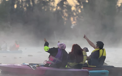 Kayakers at sunrise in Xochimilco canals, Mexico, enjoying the misty morning.