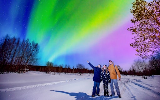 Tourists enjoying Northern Lights at Blue Lagoon geothermal spa, Iceland.