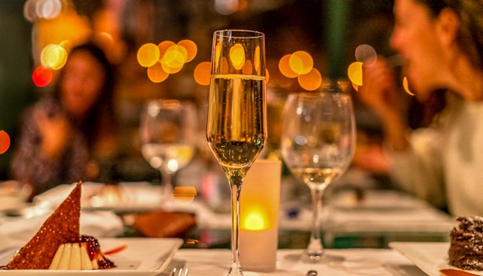 Two glasses of wine with warm lighting suggesting a gala dinner.
