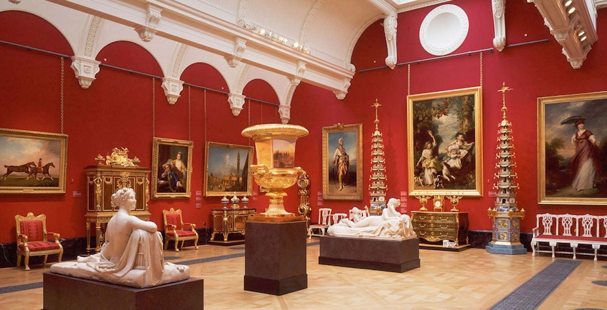 Diamond Jubilee State Coach with ornate gold detailing in front of a historic building.