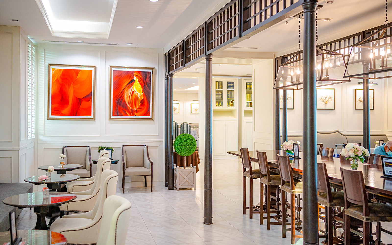 Dining area at The Coral Executive Lounge, Bangkok Airport, featuring elegant seating and vibrant artwork.