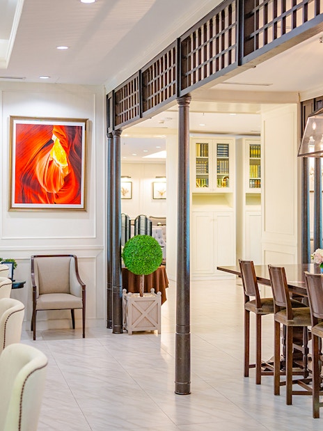 Dining area at The Coral Executive Lounge, Bangkok Airport, featuring elegant seating and vibrant artwork.