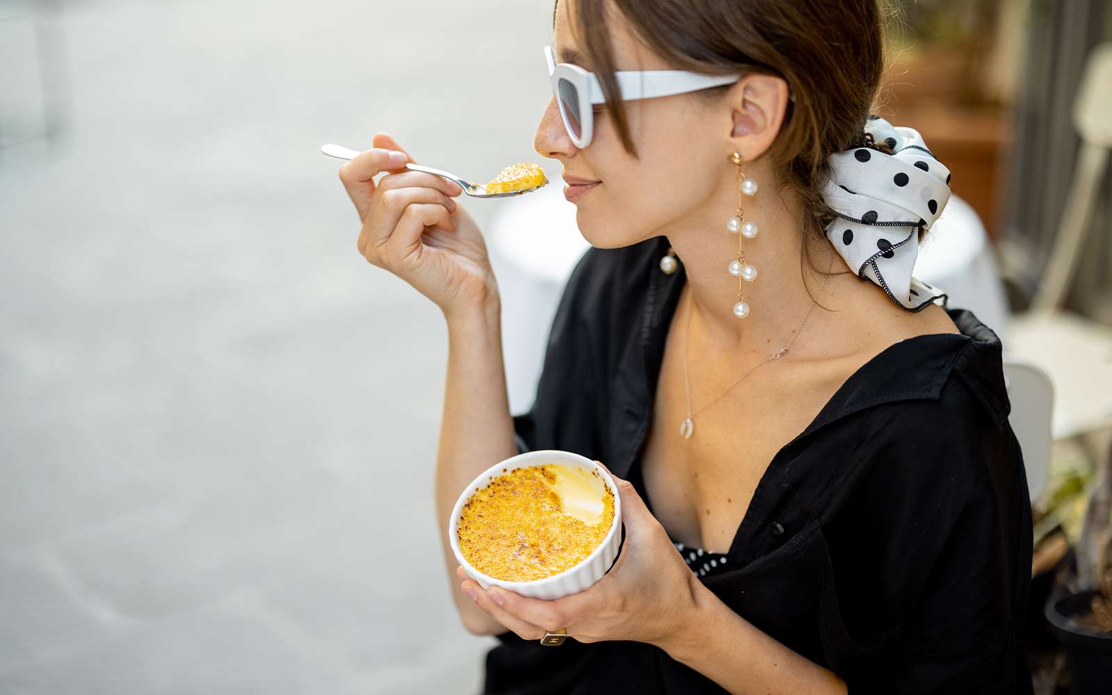Women tasting crema catalana with Montserrat mountains in the background.
