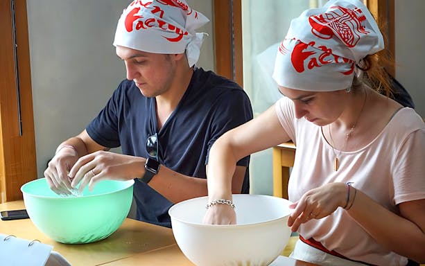 Participants making ramen at a cooking class in Ramen Factory Kyoto.