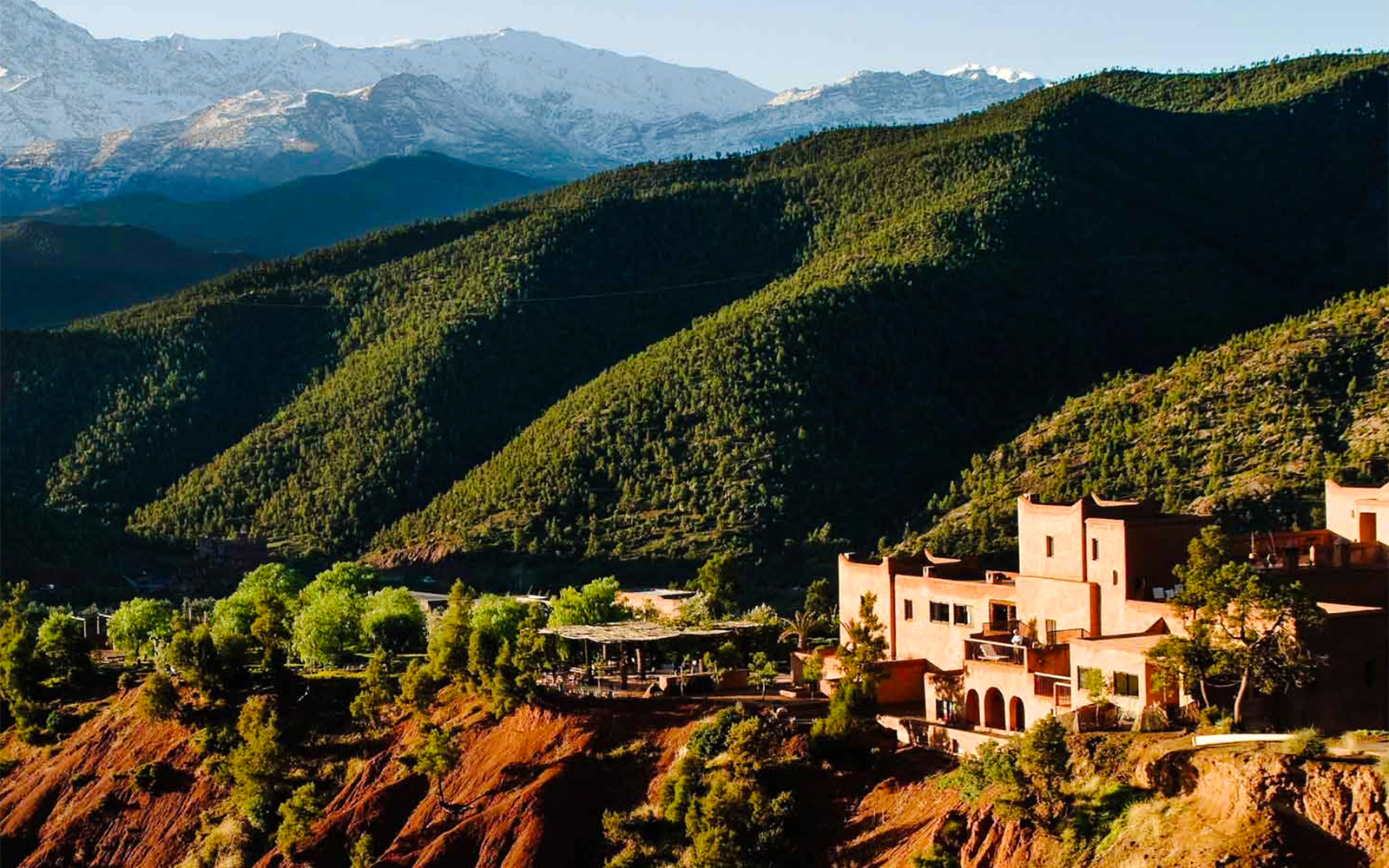 Ourika Valley landscape with traditional buildings and lush green hills.