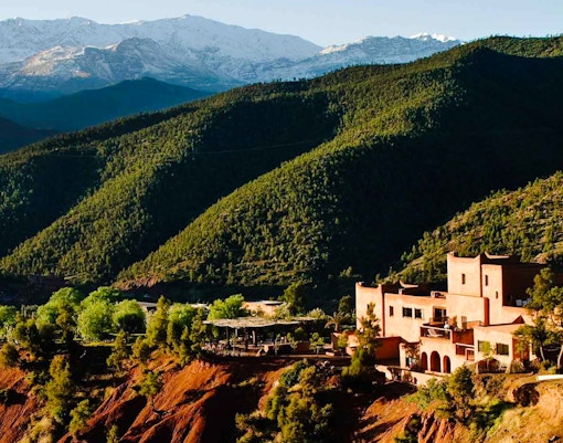 Ourika Valley landscape with traditional buildings and lush green hills.
