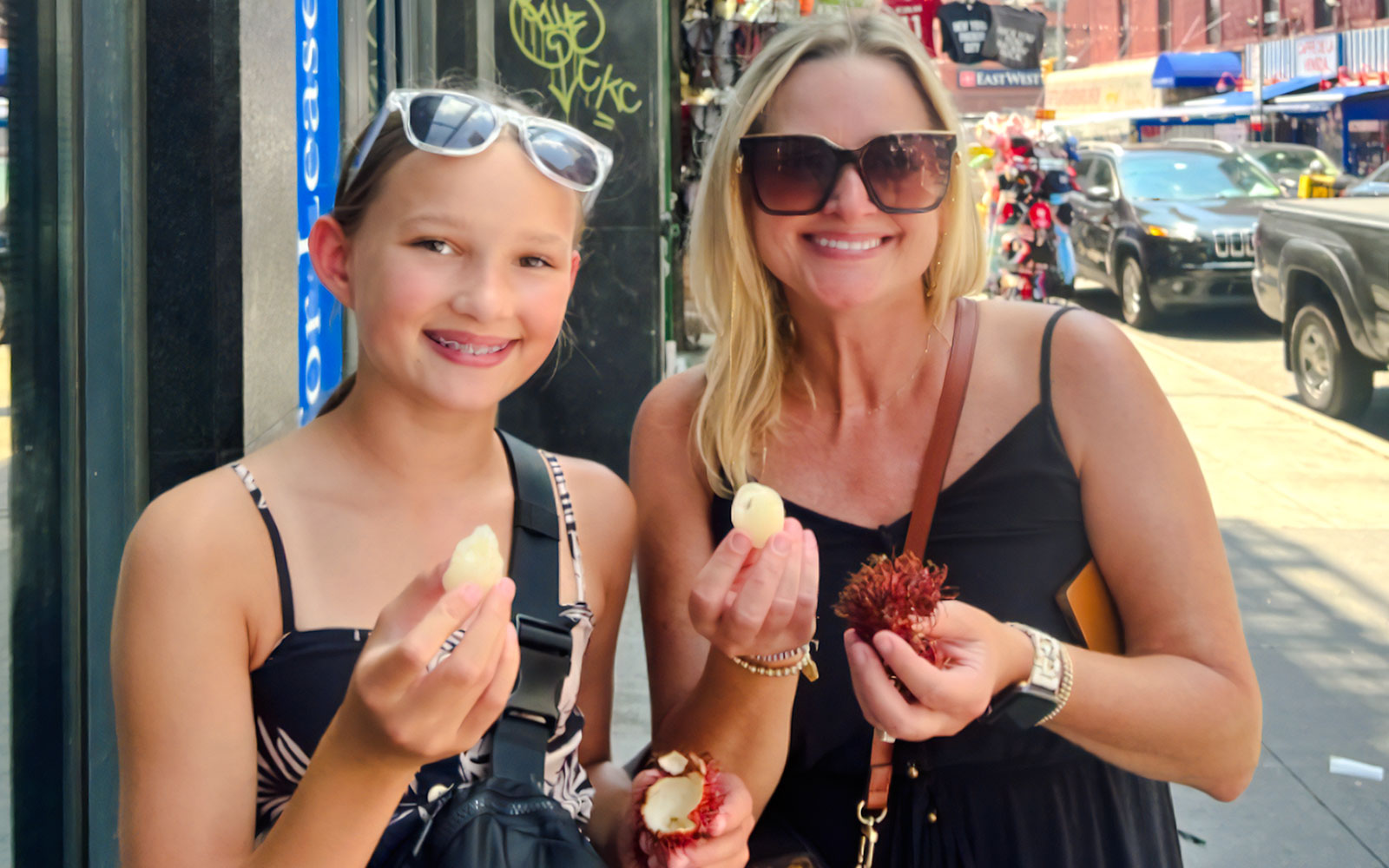 Mom and daughter enjoying lychee on Ahoy New York Food Tour.
