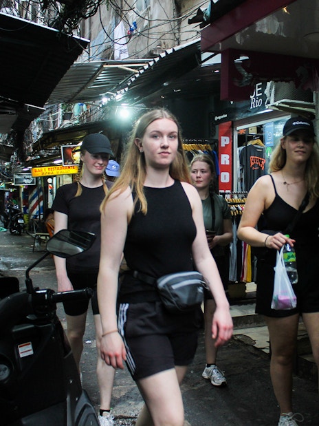 Tourists walking through a narrow street in a favela market in Rio de Janeiro.