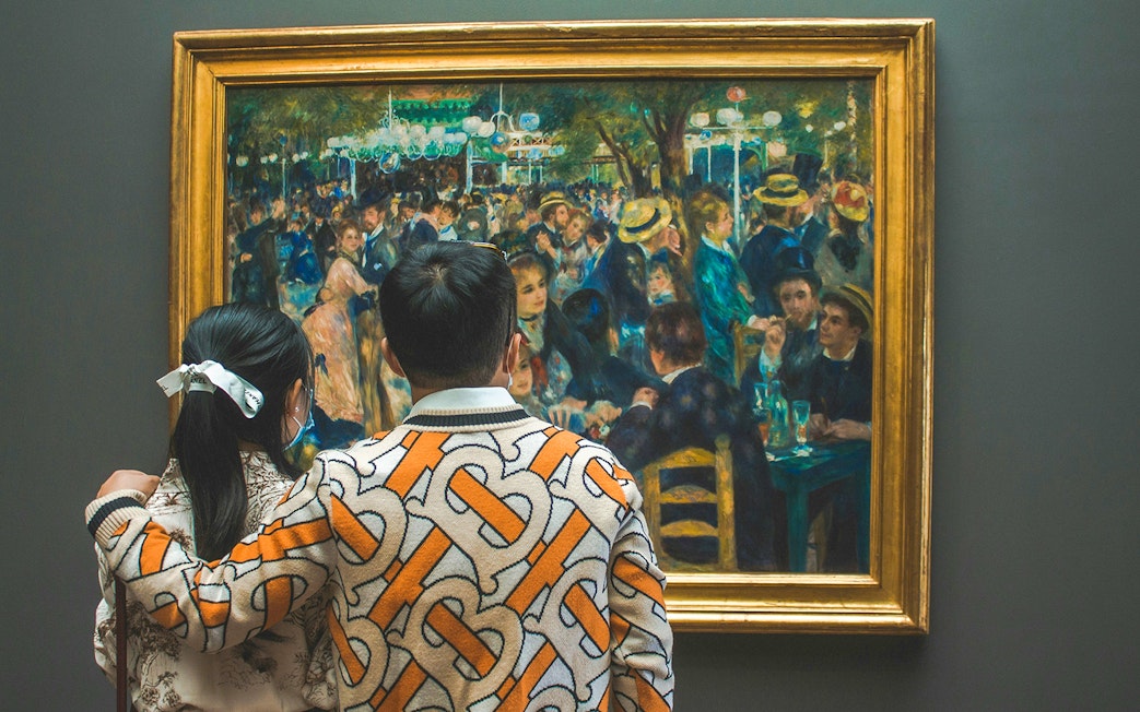 Couple viewing "Ball at the Moulin de la Galette" painting at Orsay Museum, Paris.