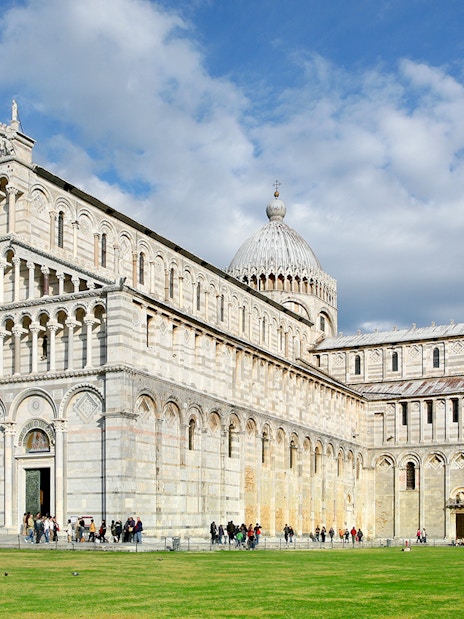 Pisa Cathedral facade with tourists, part of Pisa Monumental Complex, Italy.