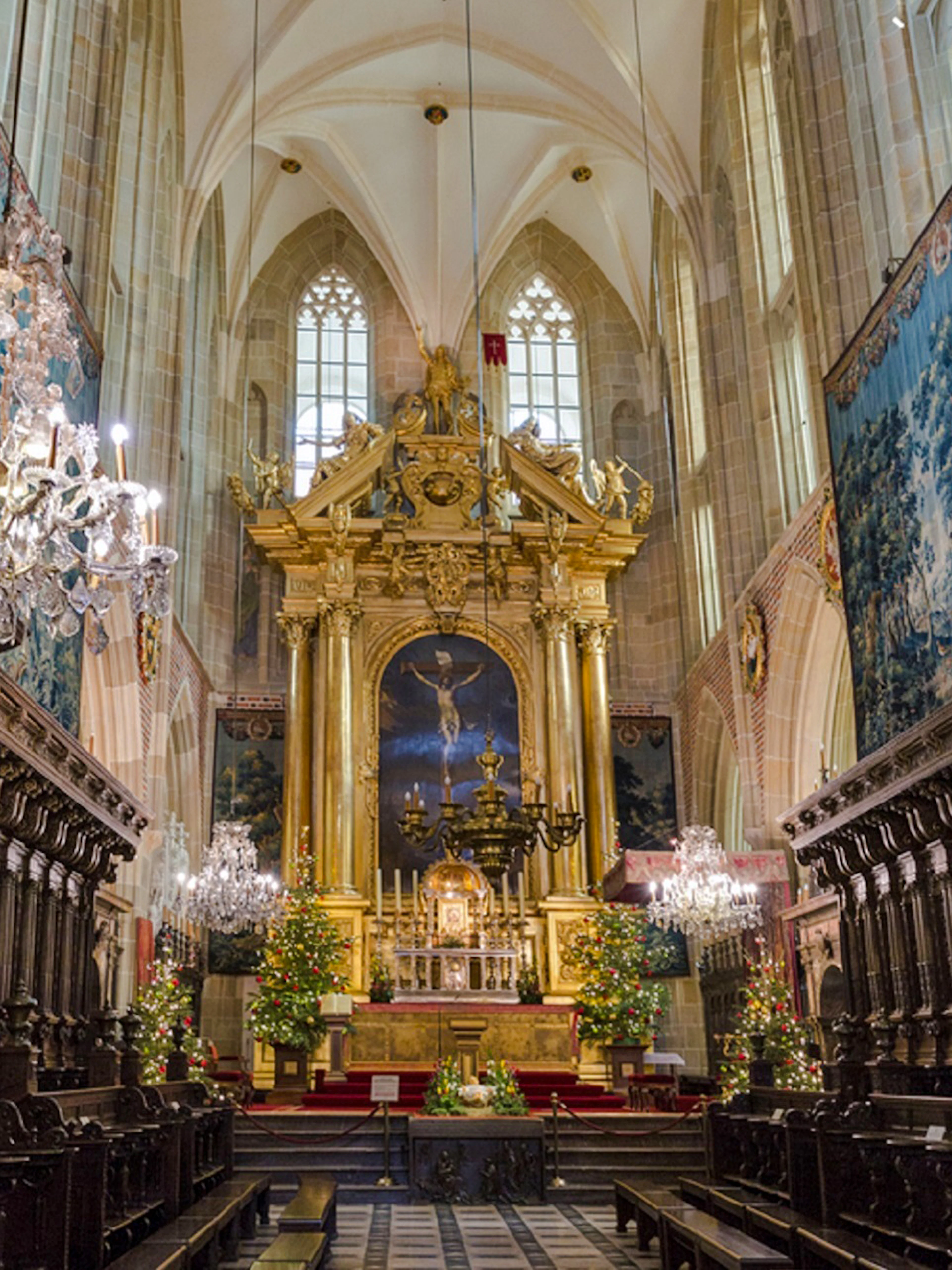 Krakow cathedral interior with ornate altar and chandeliers, part of Old Town tour.