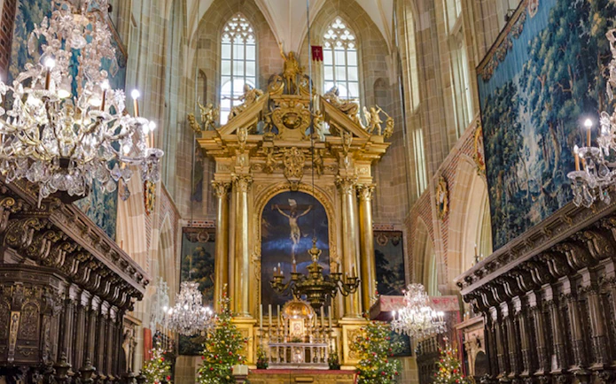 Krakow cathedral interior with ornate altar and chandeliers, part of Old Town tour.