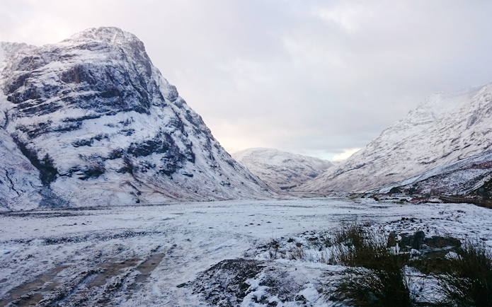 Snow-covered mountains in Glencoe, Scotland during winter.