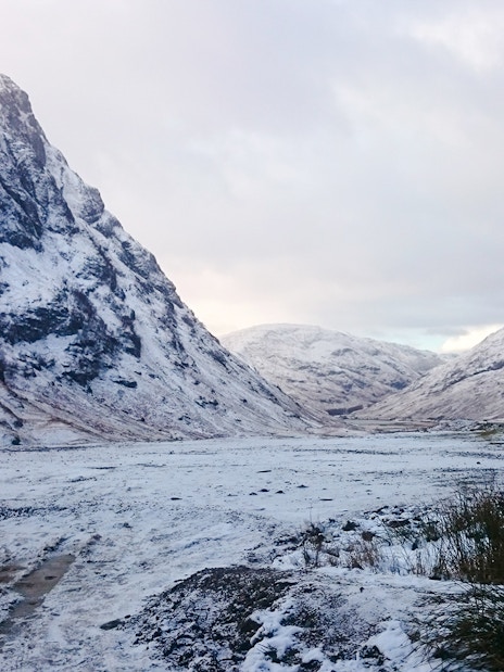 Snow-covered mountains in Glencoe, Scotland during winter.