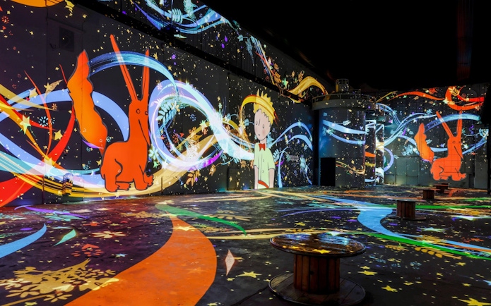 Inside Phoenix des Lumières art center with colorful digital projections.