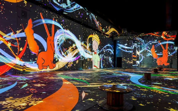 Inside Phoenix des Lumières art center with colorful digital projections.