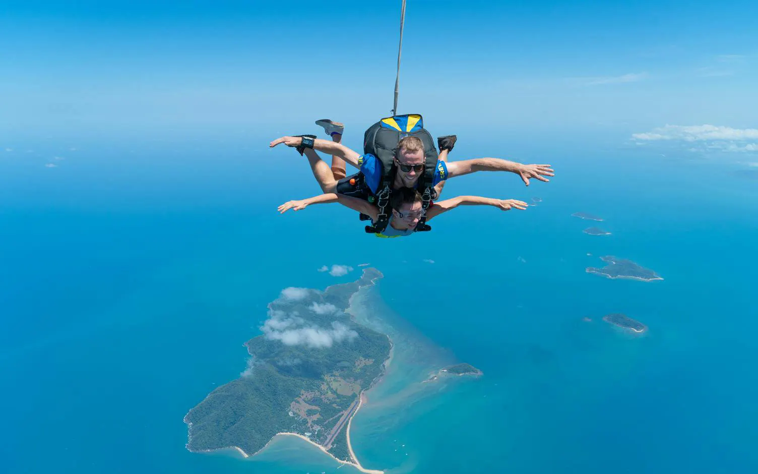 Tandem skydive over Mission Beach, Australia, with ocean and islands below.