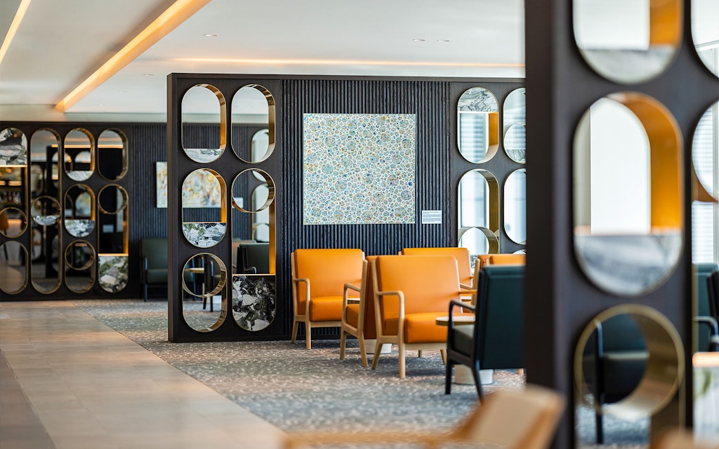 Plaza Premium Lounge seating area with modern decor and orange chairs.