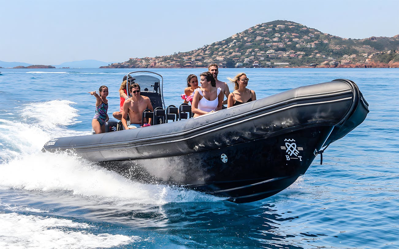 Group enjoying a boat tour near St Jean Cap Ferrat, with coastal views in the background.