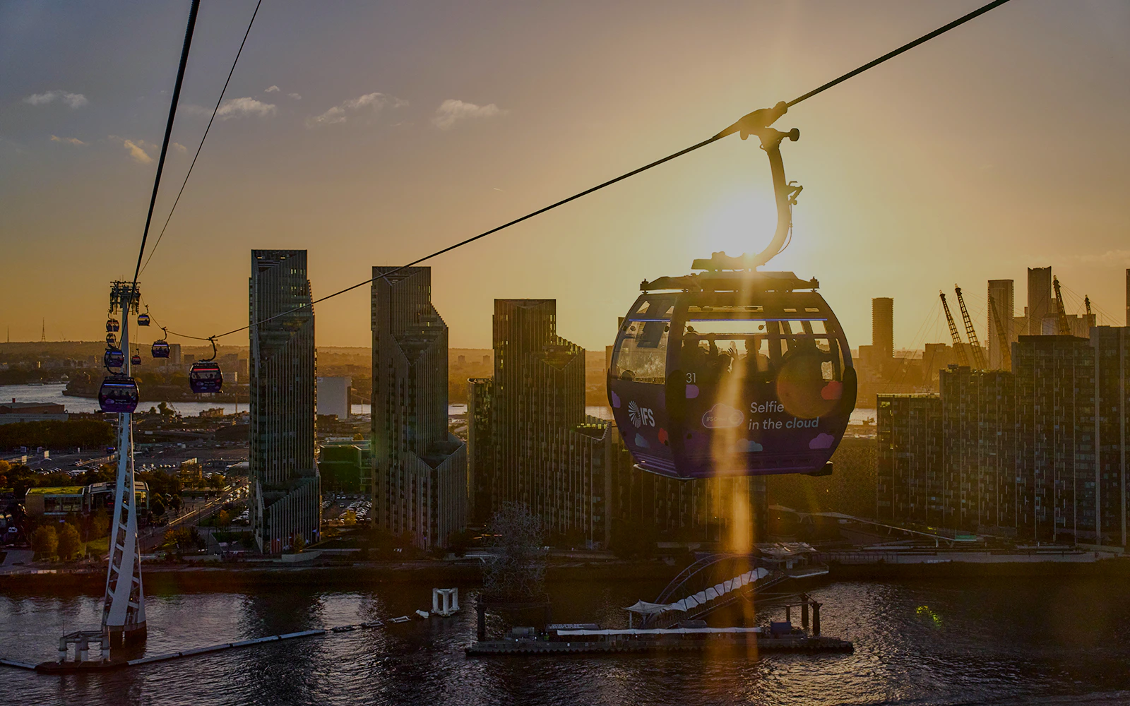 IFS Cloud Cable Car over London skyline at sundown.