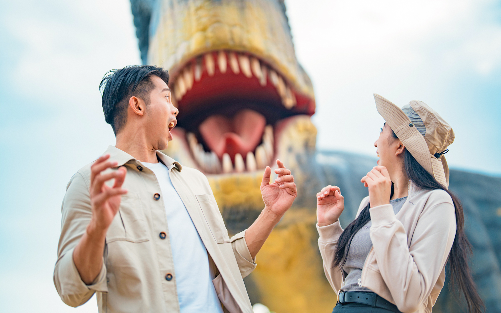 Visitors react to a large dinosaur sculpture at Dino Desert attraction.