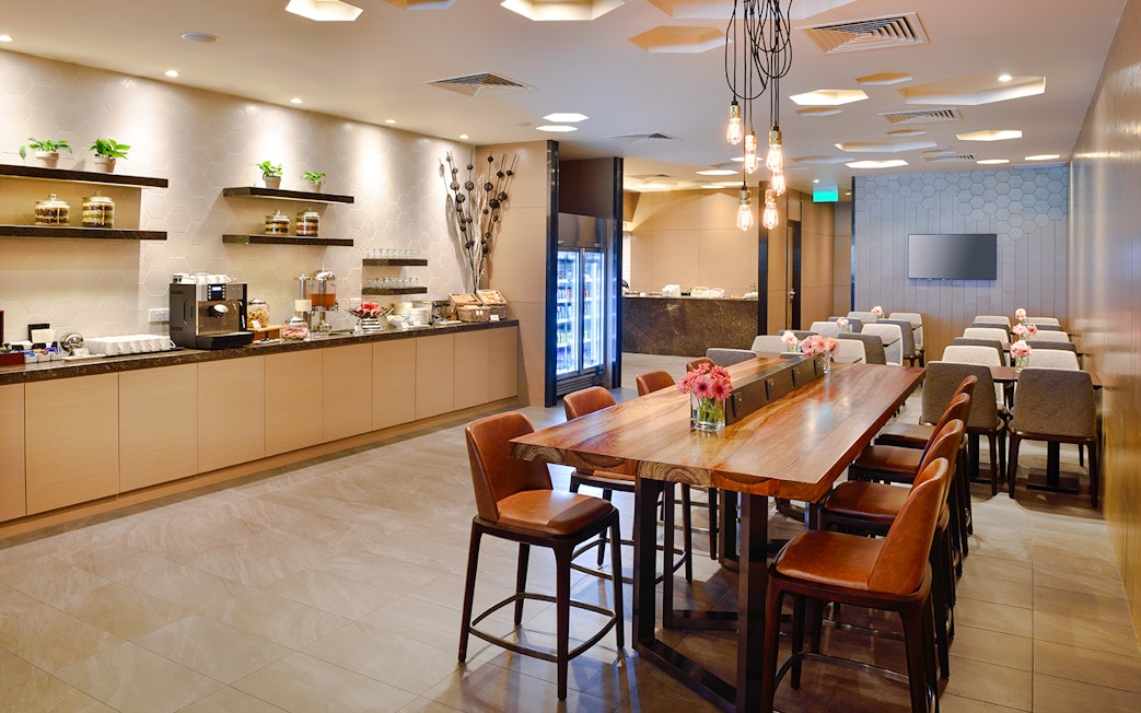 Plaza Premium Lounge dining area with seating and buffet, Singapore airport.