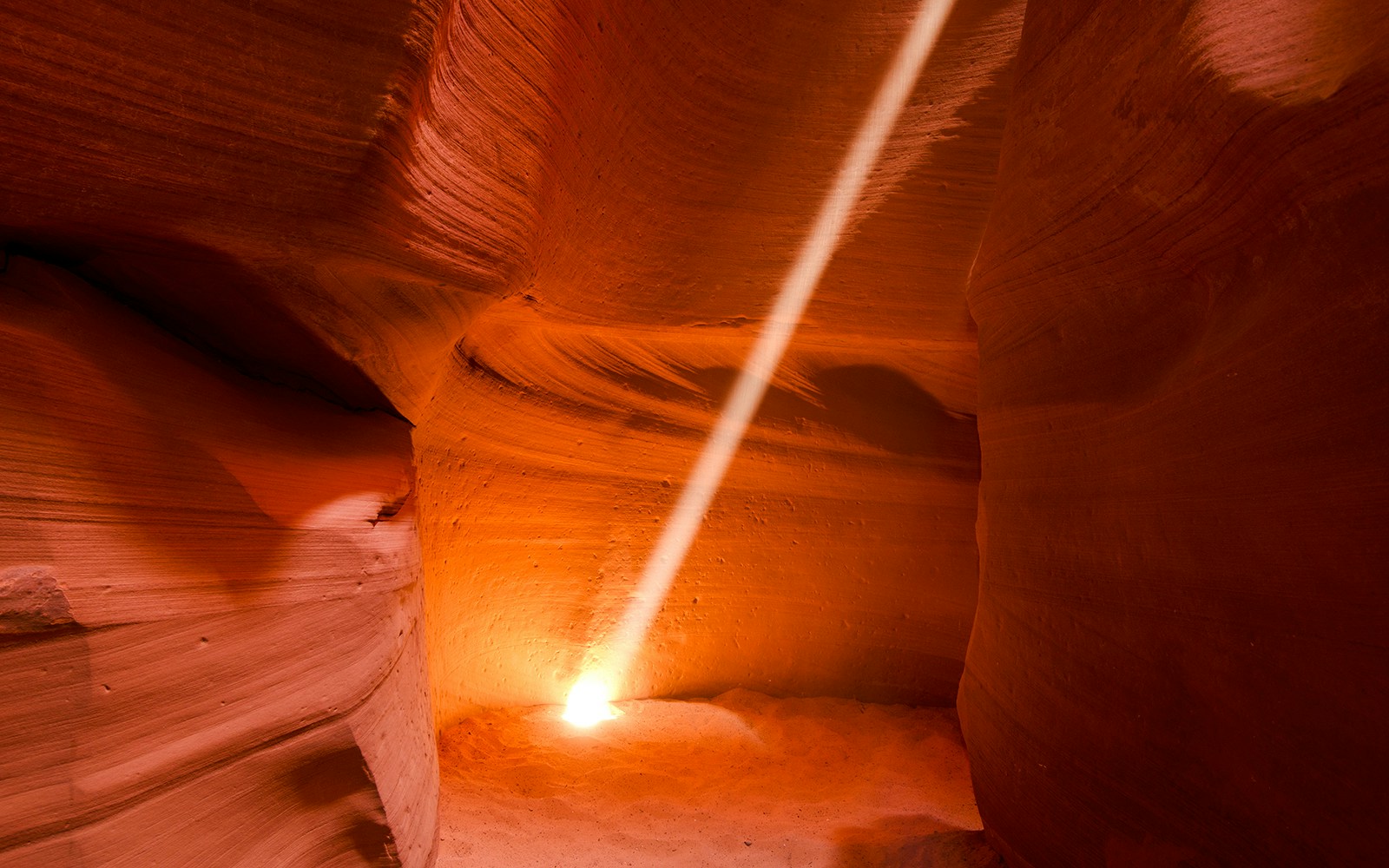 Sunbeam illuminating sandstone walls in Antelope Canyon X, Arizona.