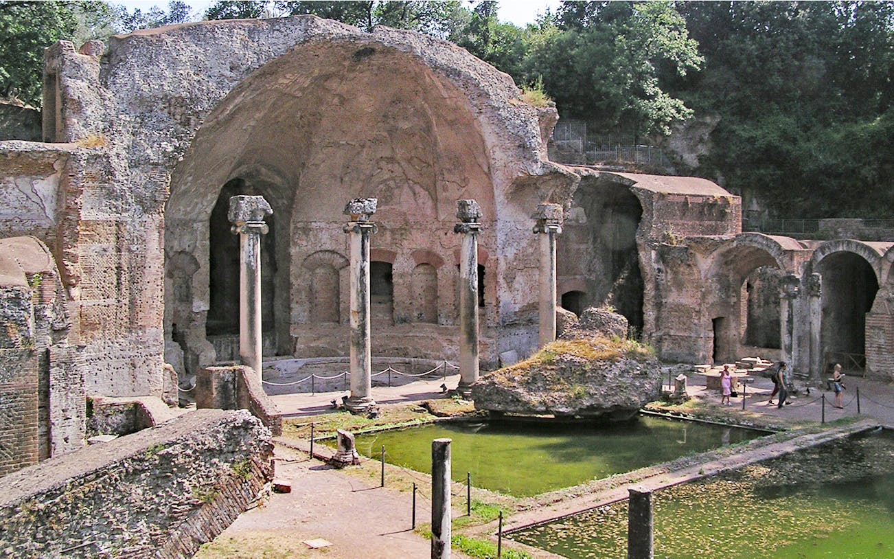 Ancient ruins and columns at Tivoli Villae, Italy, with a reflecting pool in the foreground.