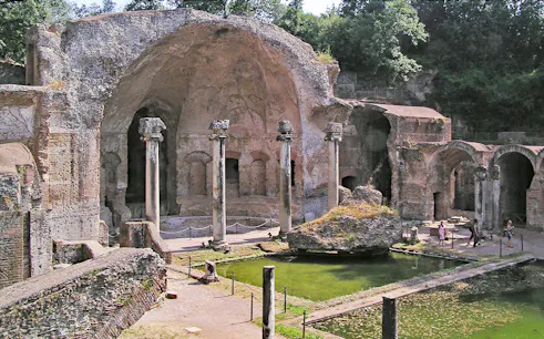 Ancient ruins and columns at Tivoli Villae, Italy, with a reflecting pool in the foreground.