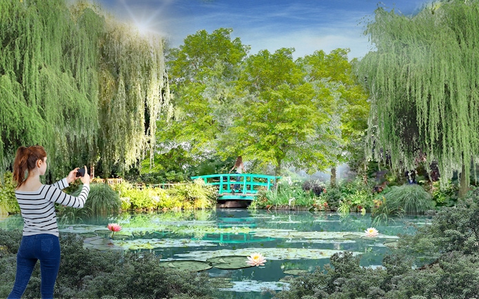 Visitor photographing lush greenery and pond at Gardens by the Bay, Singapore.