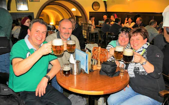 Group enjoying beer at a traditional pub in Prague during the Legendary Beer Tour.