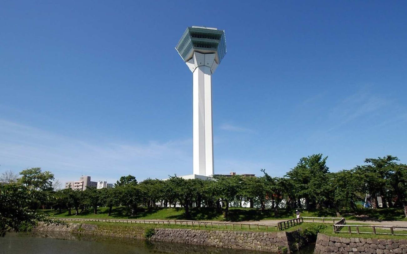 Goryokaku Tower in Hakodate, Japan, with surrounding greenery and clear sky.