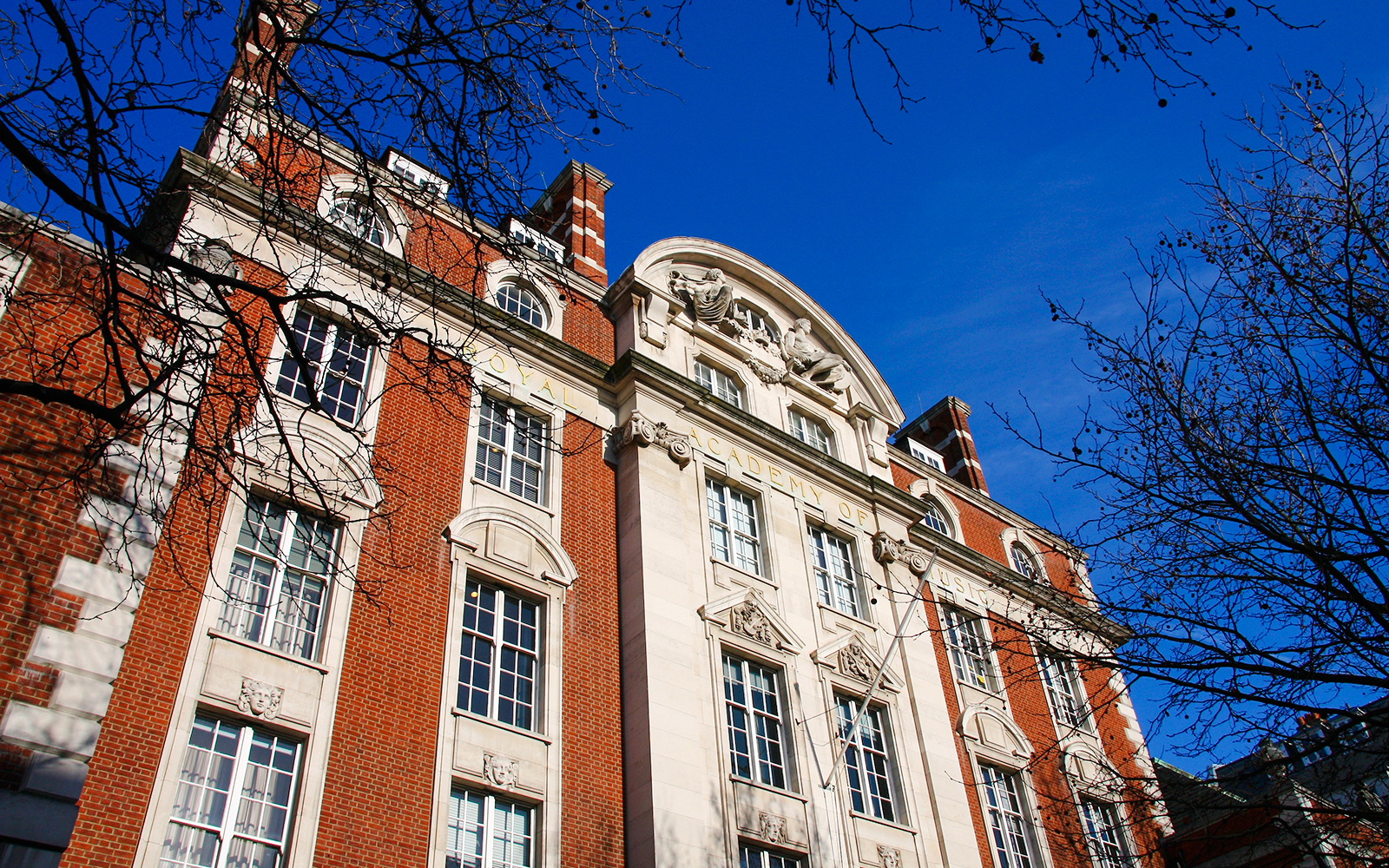 Royal Academy of Music building facade in London, UK, with clear blue sky.