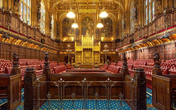 Houses of Parliament interior with ornate woodwork and red seating, London.