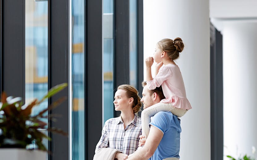 Family with luggage looking out window at Plaza Premium Lounge Rome.