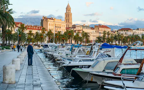 Split waterfront promenade with boats and Diocletian's Palace in the background.