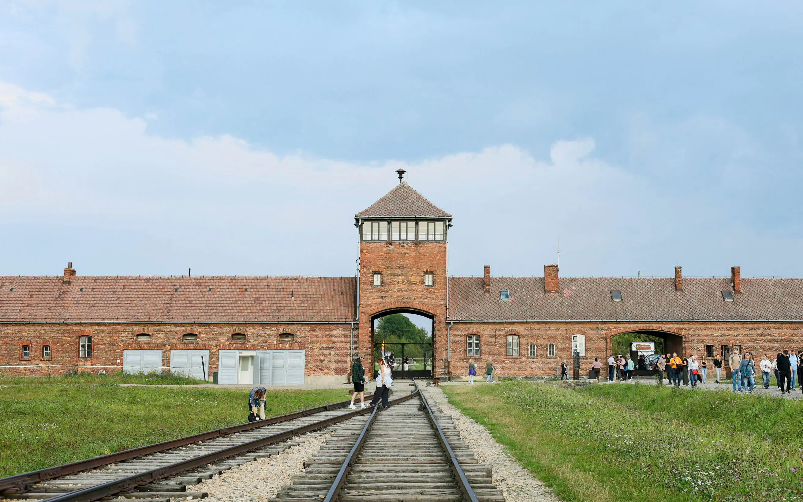 Auschwitz-Birkenau entrance with visitors on a guided tour from Krakow.